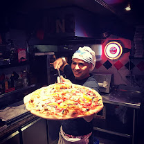 Notre pizzaiolo sortant une grande pizza du four chez Vite et Bien à Saint-Maurice